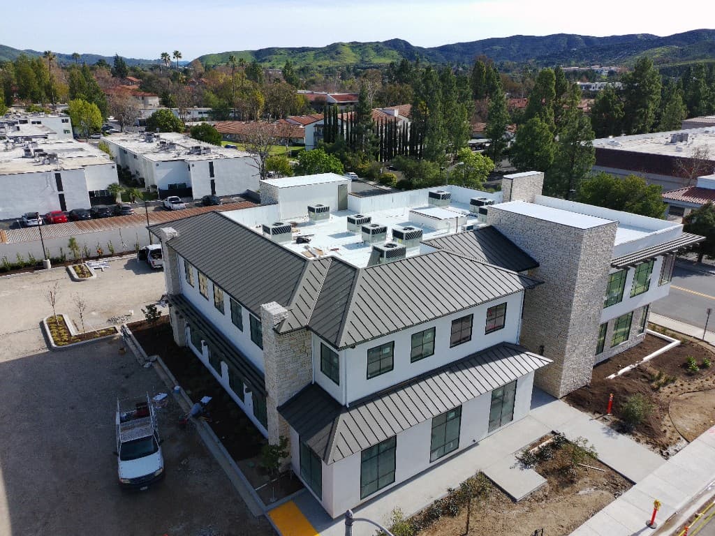 Aerial view of a commercial building with new charcoal standing seam metal roofing in Thousand Oaks